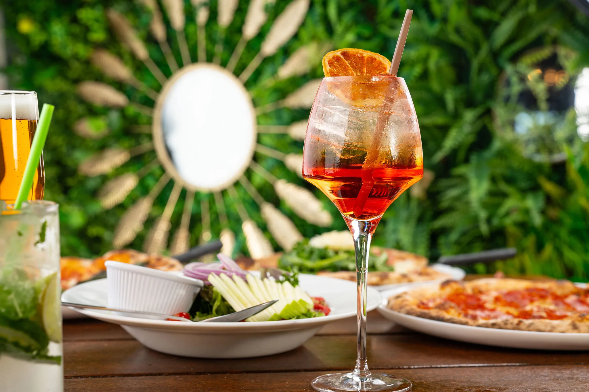 Aperol Spritz cocktail with salad and pizza
