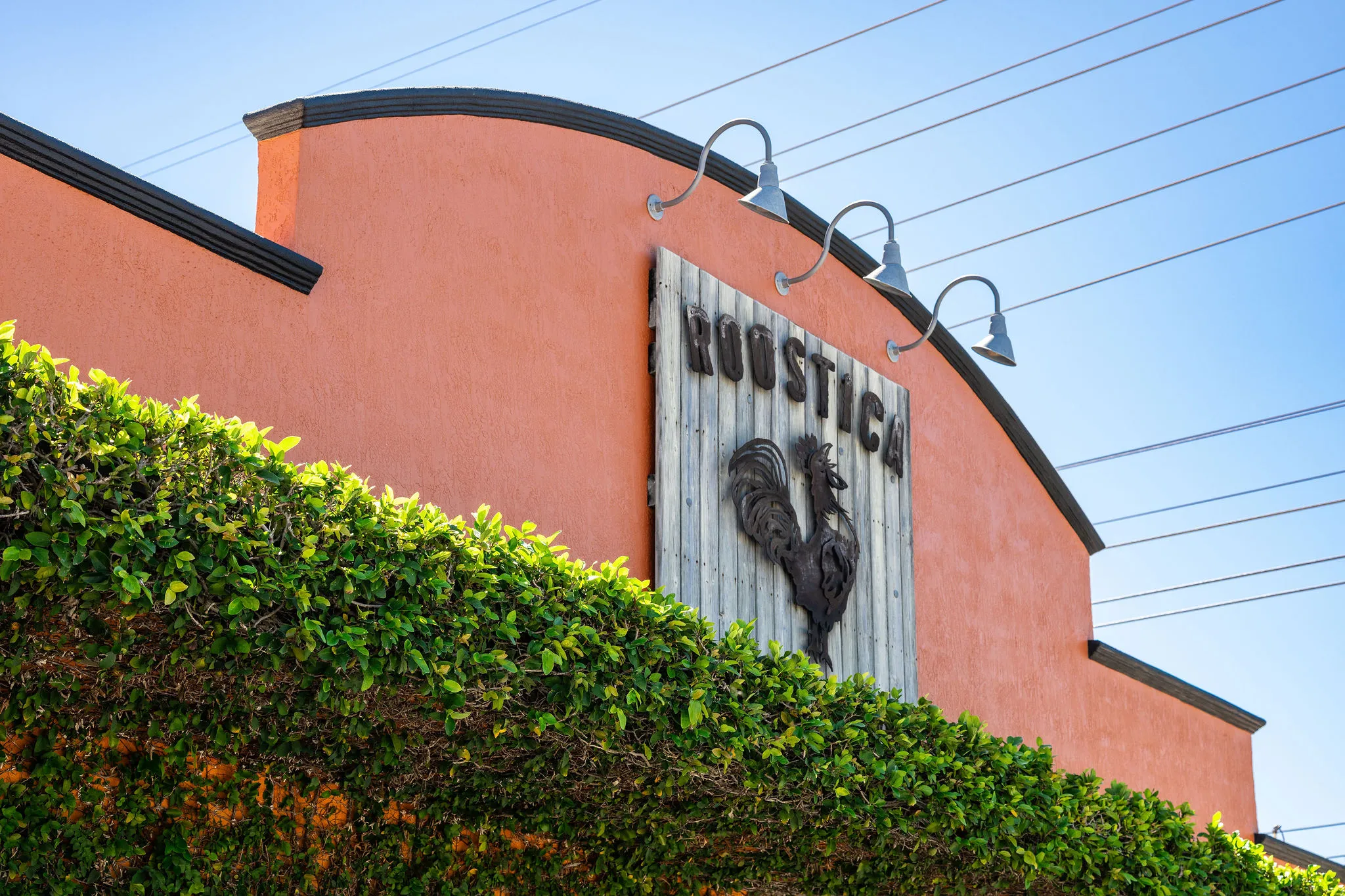 Roostica Wood-Fire Pizzeria sign with rooster logo